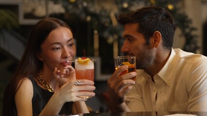 Smiling beautiful woman making a toast with Paloma cocktail to smart couple in Old fashioned savoring tasty enjoy drinking in lively conversation at bar refreshing special nightclub party. Vinosity.