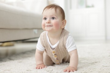 Cute little baby crawling on floor at home
