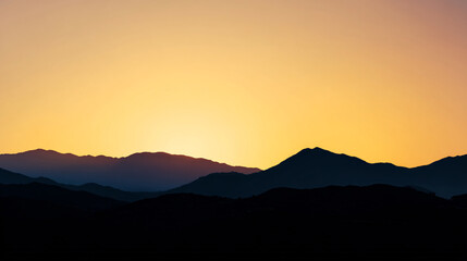Obraz premium Serene mountain range silhouette at sunset with warm golden sky, creating a peaceful and scenic landscape Concept of nature, travel, and tranquility