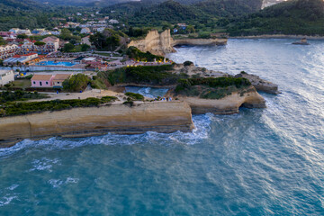Seaside bluffs rise above a resort, with waves crashing against the rocky coastline in this scenic view.