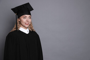 Happy student after graduation on grey background. Space for text