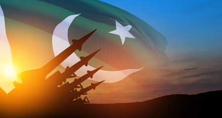 The missiles are aimed at the sky at sunset with Pakistan flag. Nuclear bomb, chemical weapons, missile defense.