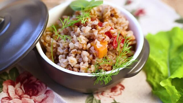 boiled buckwheat with vegetables in a ceramic bowl on a wooden table
