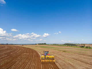 Tractor with seeder in the field. Sowing of corn, Maize in soil, with pneumatic sowing machine...