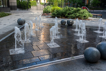 Outdoor decorative fountain with round marble sculptures and flowing water streams.