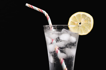 A glass of water with a straw and a lemon slice on top. Concept of refreshment and relaxation, as...