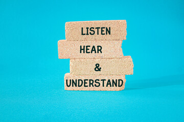 Concept words Listen, Hear and Understand on beautiful brick blocks. Beautiful blue background....