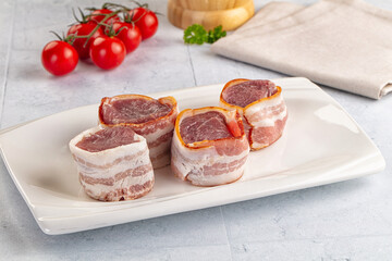 Raw pork tenferloin with bacon