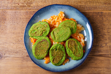 Green pea cakes on mashed carrot and parsnip. Vegetable fritters, pancakes. View from above, top studio shot