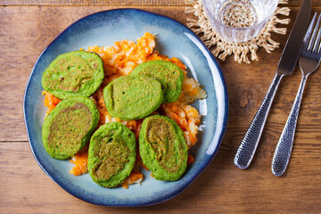 Green pea cakes on mashed carrot and parsnip. Vegetable fritters, pancakes. View from above, top studio shot
