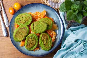 Green pea cakes on mashed carrot and parsnip. Vegetable fritters, pancakes. View from above, top studio shot