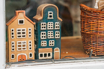 Indoor setting with two miniature Dutch houses White, black, red, and brown colored structures with pointed roofs and gabled facades Various window styles, close proximity suggesting community or n