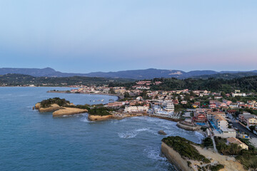 Scenic coastal town nestled by the Ionian Sea, featuring rocky formations and lush green landscapes.