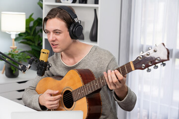 Host channel in smart singer with smiling face, playing guitar along singing, broadcasting on...