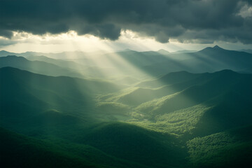 light beams clouds through clouds illuminating mountains in a valley