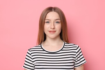Fototapeta premium Portrait of smiling teenage girl on pink background