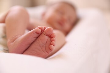Little baby lying on bed indoors, selective focus. Space for text