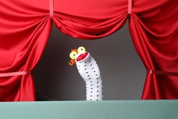 Creative puppet show on stage with red curtains