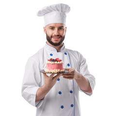 Happy confectioner in uniform holding delicious cake with berries on white background