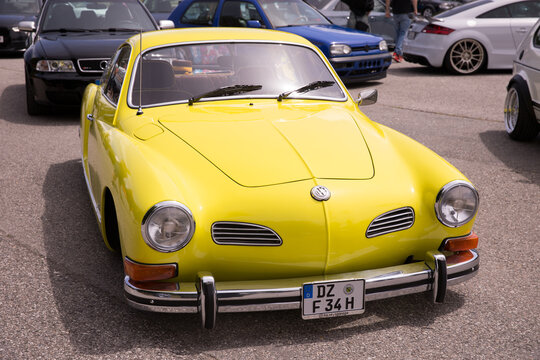 Vintage yellow volkswagen karmann ghia in a car show setting gti treffen