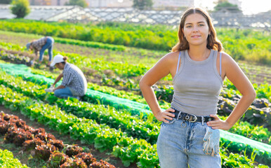 Female worker is resting standing in field after completing tasks, harvesting at local farmers...