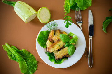Golden fried zucchini on a brown background