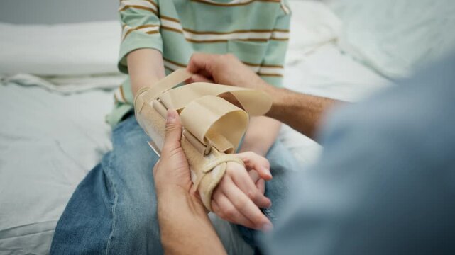 Close up of pediatric patient receiving orthopedic wrist brace after arm injury.