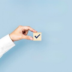 Gros plan sur une main qui pose des cubes pour valider des étapes dans un projet 