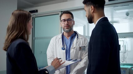 Pharmaceutical sales respresentatives showing doctor new medications. Group presentation in hospital setting.