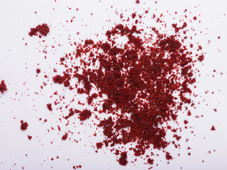 A scattering of deep red velvet cake crumbs on a white background
