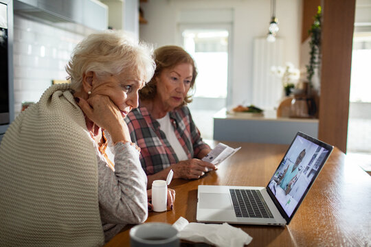 Worried senior lesbian couple having video call with doctor from home - Powered by Adobe