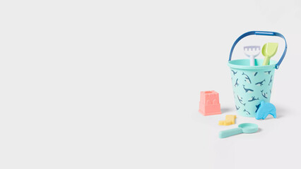 Colorful beach bucket set with shovel and molds preparing for summer fun at the seaside.