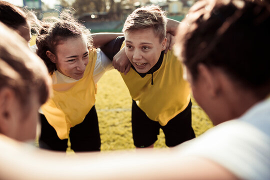 Female soccer team in huddle before game on outdoor field