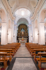 The church interior features high vaulted ceilings, ornate columns, a golden altar with a crucifix,...