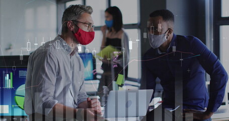 Data processing over diverse two male colleagues wearing face masks using laptop at office