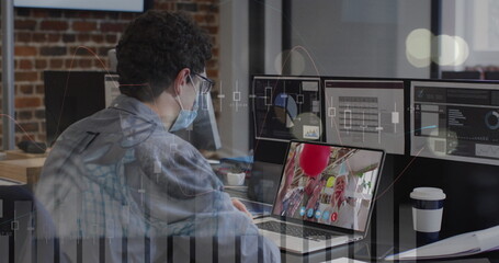 Data processing over caucasian man wearing a face mask having a image call on laptop at office