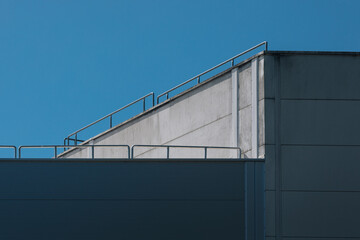 Obraz premium Minimalist Industrial Roofline with Safety Rail against a Clear Blue Sky