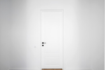 White interior door in the room with white wall