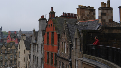 Man on balcony admiring the beautiful medieval city of Edinburgh, Scotland UK