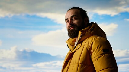 Male explorer embraces the solitude of high altitude wilderness, climbing on top of the mountain for fresh air and a scenic background. Mindfulness and relaxation in the nature. Camera B.