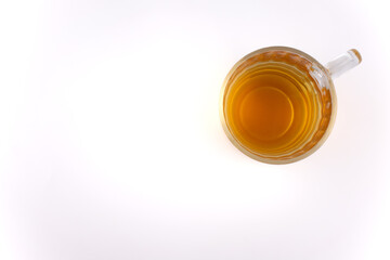 This overhead shot features a glass mug of green tea, radiating warmth and tranquility against a...