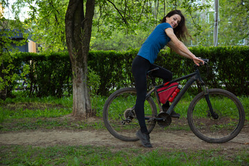 Beauty joy woman with long brown hair biking on bicycle on spring trees background and looking fun....