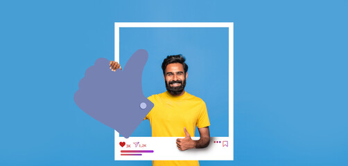 A smiling man in a yellow shirt stands against a blue background, showcasing positivity with a...