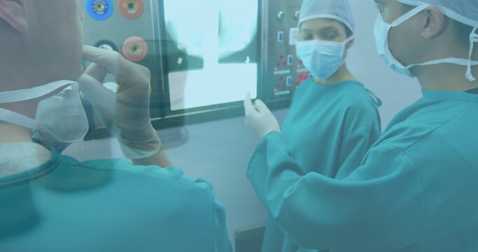 Financial data processing over team of diverse surgeons discussing in operation theatre