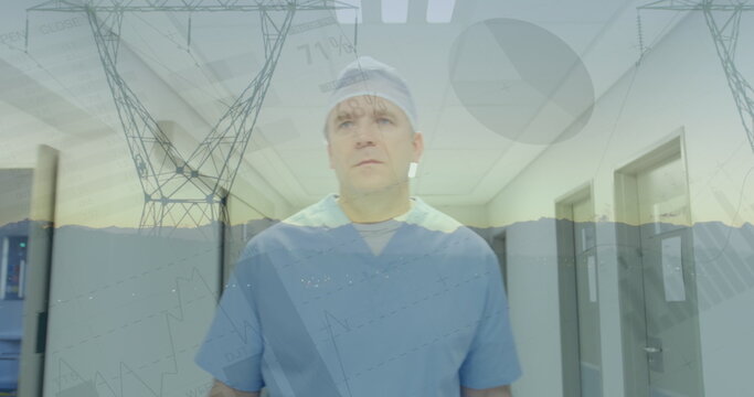 Image of financial graphs over caucasian male doctor and electricity poles at sunset