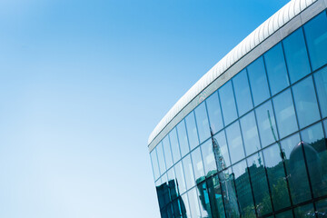 Contemporary architecture building with glass and metal facade on clear blue sky. For illustrating...