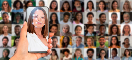 A hand holds a smartphone showing a facial scan. In the background, a collage of diverse faces highlights the use of modern technology for identification and recognition in everyday life.