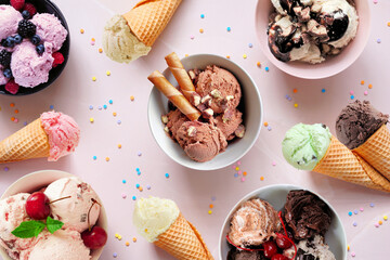Summer ice cream table scene. Bowls and cones of colorful assorted flavors. Top view on a soft pink stone background.