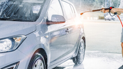 Automobile washing. Car foam bubbles spray. Shiny wet vehicle cleaning.