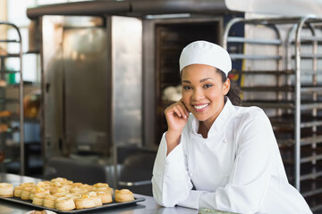 Baking trays holding golden-brown pastries on stainless steel countertop in bakery kitchen